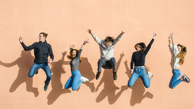 Jugendliche vor einer Wand, die in die Luft springen